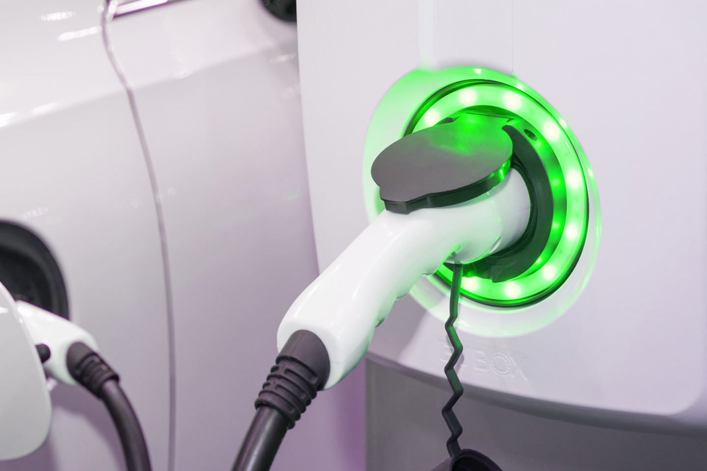 close up of green electric car charger plugged in