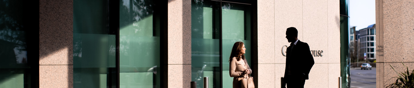 Two people standing outside Gaspe House, a finance building in Jersey
