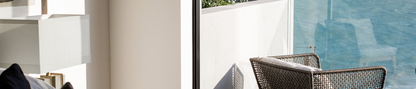 Chair on a balcony off the bedroom, looking out to the sea