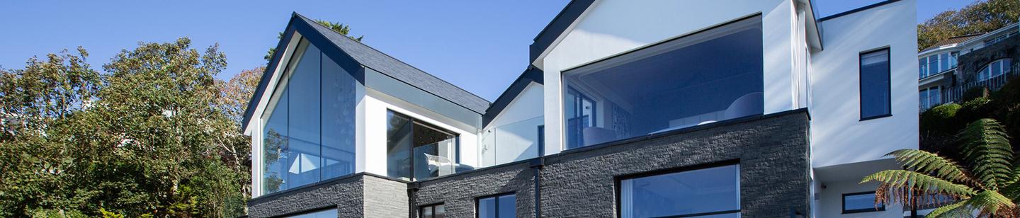 Modern house with decking, deck chairs, and large windows in Fort George
